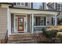 Inviting front porch with stone steps, a red front door, and classic architectural details at 154 Hunters Hill Dr, Statesville, NC 28677