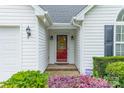 Close-up of the front door with a decorative sunflower wreath, sidelights, and manicured landscaping at 199 Ashmont Dr, Kannapolis, NC 28081