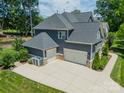 Rear exterior view featuring a three-car garage and well-maintained landscaping in a suburban community at 208 South Shore Dr, Belmont, NC 28012
