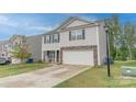 Traditional-style home with a large front yard, attached garage and light colored siding on a sunny day at 2859 Sherrills Stream Dr, Sherrills Ford, NC 28673