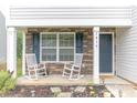 Inviting front porch featuring white rocking chairs and decorative stone accents, creating a cozy outdoor space at 2859 Sherrills Stream Dr, Sherrills Ford, NC 28673