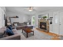 Cozy living room with a stone fireplace, plush seating, and natural light from a window at 2934 Drakes Crossing Dr, Charlotte, NC 28262