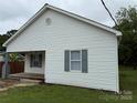 Charming single-story home with white siding and gray shutters and a wooden front porch at 303 Southern Ave, East Spencer, NC 28039