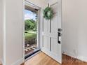 Bright entryway with hardwood floors, a white door with wreath, and a view to the yard at 3042 Cresthill Dr, Charlotte, NC 28212