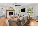 Bright living room with a fireplace, hardwood floors, large windows, and a comfortable seating area at 3042 Cresthill Dr, Charlotte, NC 28212