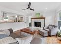 Cozy living room featuring a brick fireplace, hardwood floors, and an open view to the kitchen at 3042 Cresthill Dr, Charlotte, NC 28212
