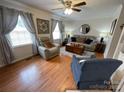 Cozy living room with hardwood floors, a ceiling fan, and comfortable furnishings at 311 Tiffany Nw St, Concord, NC 28027