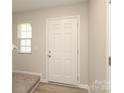 Bright entryway with light-colored walls, a white door, and carpeted stairs leading to the upper level at 3349 Ellingford Rd, Charlotte, NC 28214
