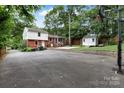 Spacious backyard featuring a screened porch, storage shed, and ample paved area at 3624 Moultrie St, Charlotte, NC 28209