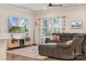Cozy living room with hardwood floors, ceiling fan, a gray sectional, and bright natural light at 500 Cedar Knoll Cir, Pineville, NC 28134