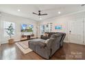 Comfortable living room featuring hardwood floors, a ceiling fan, and a plush gray sectional at 500 Cedar Knoll Cir, Pineville, NC 28134