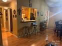 Inviting living space featuring wood floors, a pass-through to the kitchen, and barstool seating at 5816 Rocky Mount Ct, Charlotte, NC 28214