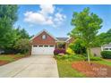 Beautiful brick home featuring a two-car garage, lush landscaping, and a well-manicured lawn, creating a picturesque setting at 6007 Edinburgh Ln # 214, Indian Land, SC 29707