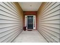 Inviting front porch with a classic black door, framed by neutral siding and brick accents, offering a warm welcome at 6007 Edinburgh Ln # 214, Indian Land, SC 29707