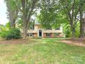 Traditional home with a welcoming lawn, mature trees, and a charming exterior at 7021 Willow Bend Ln, Mint Hill, NC 28227