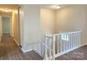 Upstairs hallway with vinyl floors and white railing overlooking the spacious downstairs living area at 7021 Willow Bend Ln, Mint Hill, NC 28227