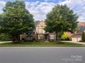 Charming two-story Tudor home with brick facade, gable roof, manicured lawn, and mature trees at 7620 Caspian Dr, Waxhaw, NC 28173