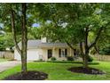 Inviting two-story home with a front porch, lush lawn and mature trees at 8808 Palmutum Pl, Charlotte, NC 28269