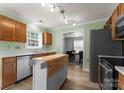 Well-lit kitchen featuring stainless steel appliances, wooden cabinets, and a functional island at 8808 Palmutum Pl, Charlotte, NC 28269