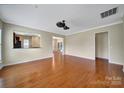 Open living room with hardwood floors, a ceiling fan, and seamless flow to kitchen and dining areas at 9020 Smokey Hill Ln, Fort Mill, SC 29707