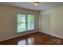 A bright bedroom with hardwood floors, closet space, and a large window bringing in natural light at 1115 Dumbarton Rd, Gastonia, NC 28054
