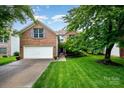 Charming two-story brick home with a well-manicured lawn and attached two-car garage at 116 Amber Woods Dr, Tega Cay, SC 29708