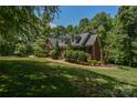 Traditional brick home showcasing a well-manicured lawn with mature trees at 118 Tayport Dr, Troutman, NC 28166