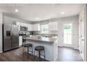 Modern kitchen with white cabinets, stainless steel appliances, a kitchen island and wood-look flooring at 12013 Beaux Art Ln, Charlotte, NC 28214