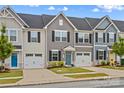 Charming townhome exterior featuring a well-manicured lawn, attached garage, and classic architectural details at 124 Kristin View Ln # C, Troutman, NC 28166