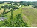 An expansive, lush, green aerial view of farmland and a house, with many mature trees at 13101 Pine Bluff Rd, Midland, NC 28107