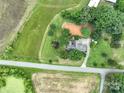 Overhead view of a house, a driveway, a road and some farmland with tire tracks at 13101 Pine Bluff Rd, Midland, NC 28107