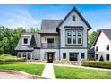 Beautiful home with a manicured front lawn, stone details, board and batten and stucco exterior at 14105 Ryker Way, Davidson, NC 28036
