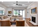 Bright living room with hardwood floors, a fireplace, large windows, and comfortable seating at 14105 Ryker Way, Davidson, NC 28036