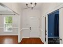 Inviting foyer with hardwood floors, white walls, and natural light from nearby windows at 14616 Pomerol Ln, Pineville, NC 28134