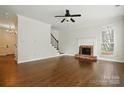 Spacious living room featuring hardwood floors, a brick fireplace, and staircase at 14616 Pomerol Ln, Pineville, NC 28134
