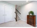 Neutral stairway with carpeted steps, wooden handrail, and a vintage radio at 1839 Shumard Ln, Charlotte, NC 28205