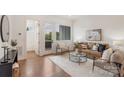 Bright living room boasts hardwood floors, neutral decor, a balcony, and comfortable seating for relaxing and entertaining at 2653 Shenandoah Ave, Charlotte, NC 28205