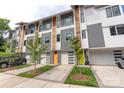 Exterior view of modern townhomes showcasing gray siding, colorful doors, and well-maintained landscaping at 2653 Shenandoah Ave, Charlotte, NC 28205