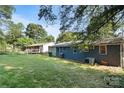 Spacious backyard with green lawn and mature trees, offering a serene outdoor setting at 2701 Ravencroft Dr, Charlotte, NC 28208