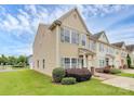 Attractive tan siding townhouse with teal door, blue shutters and manicured landscaping at 2840 Hopeton Ct, Monroe, NC 28110