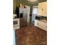 Functional kitchen with stainless steel refrigerator, white cabinets, and contrasting countertops at 325 N Caldwell Ave, Newton, NC 28658