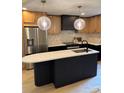 An open kitchen features stainless steel appliances, a black island, and stylish pendant lighting at 3326 Winterfield Pl, Charlotte, NC 28205