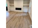 A bright living room with modern fireplace, built-in shelves, and light wood flooring at 3326 Winterfield Pl, Charlotte, NC 28205