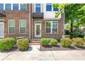 Close-up of a brick townhome with a glass front door and neatly trimmed shrubbery at 420 E 16Th St, Charlotte, NC 28206