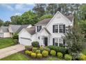 Charming two-story home featuring a landscaped front yard, attached garage, and classic white siding with black shutters at 4407 Beauvista Dr, Charlotte, NC 28269