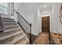 Welcoming entryway with staircase, dark wood flooring, and a decorative area rug leading to a wooden door at 5118 Waldron Meadow Dr, Charlotte, NC 28226