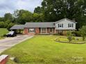 Classic two-story home with a well-kept lawn, complemented by mature trees and convenient covered parking at 6561 Weldon Nw Cir, Concord, NC 28027