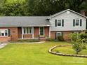 Inviting two-story brick home with a manicured front yard and lush landscaping, offering a picturesque suburban appeal at 6561 Weldon Nw Cir, Concord, NC 28027
