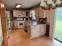 Functional kitchen featuring natural-toned cabinets, modern appliances, and a bright, open dining area with backyard views at 6561 Weldon Nw Cir, Concord, NC 28027