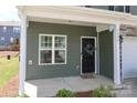 Close-up of a charming front porch with a black door and neatly kept landscaping at 7024 Jane Parks Way, Charlotte, NC 28217